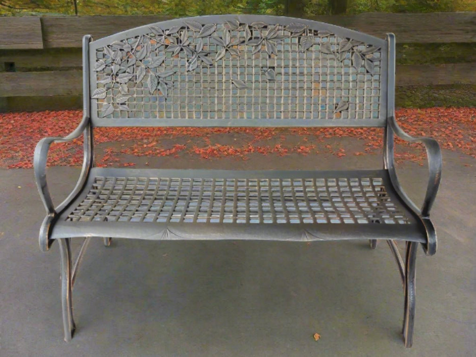 A solid cast iron construction garden bench with a bronze powder coat finish and gold highlights, featuring a grid design and leaves patterns on the backrest.