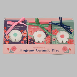 Packaged fragrant ceramic discs with floral design on a white background