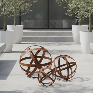 Three rusted metal decorative spheres with intersecting curved bands, shown on a clean white background.
