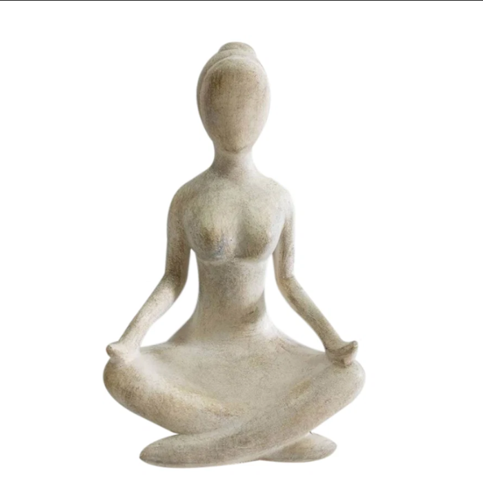 A minimalist, abstract female figurine sculpted in a meditative lotus pose, made from a textured stone-like material in a warm beige or off-white color, isolated on a white background.