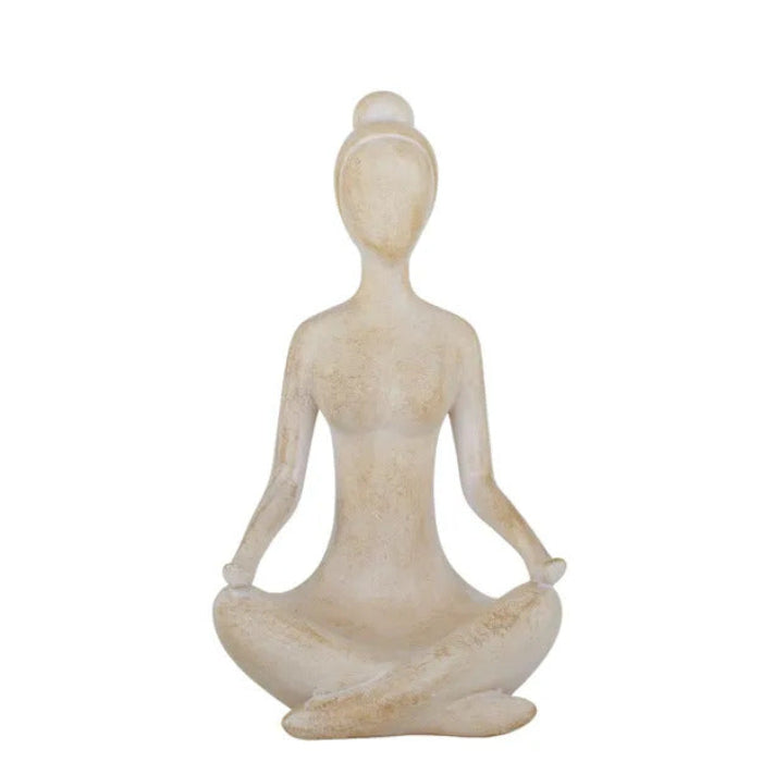 A minimalist, stylized figurine of a meditating female figure in a lotus position, crafted from a textured cream-colored stone or resin with a distressed, rustic finish.