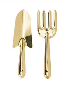 Gold-colored gardening trowel and fork on a white background