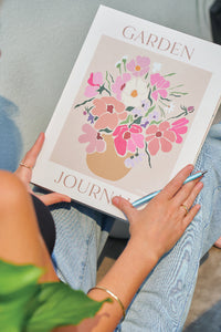 Person holding a garden journal with floral design
