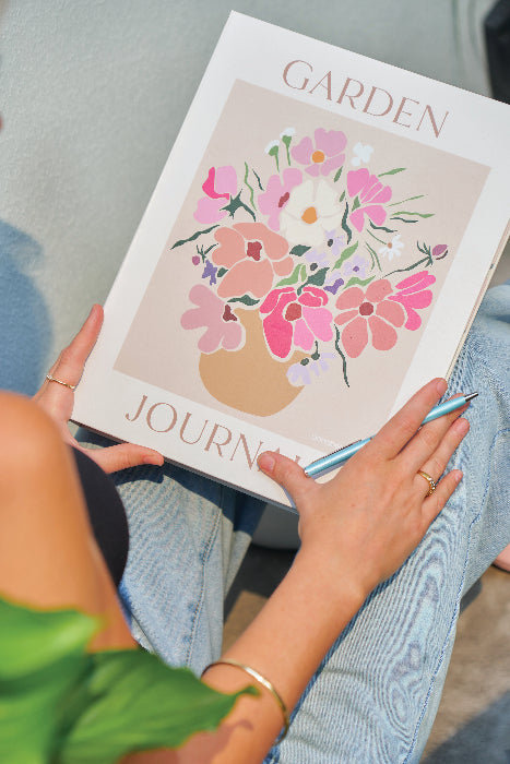 Person holding a garden journal with floral design