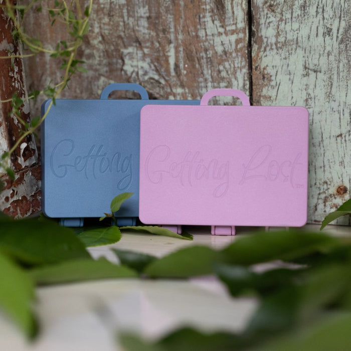 Two small suitcases with 'Getting Ready' text on a wooden background with greenery.