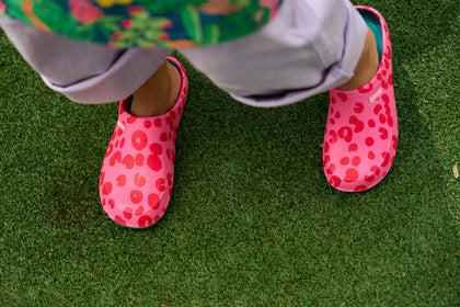 Pink shoes with red polka dots on a green grassy surface