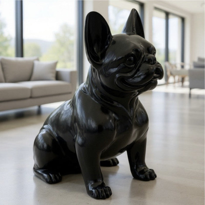 A glossy black ceramic French Bulldog statue sitting on a light-colored floor in a modern living room setting.