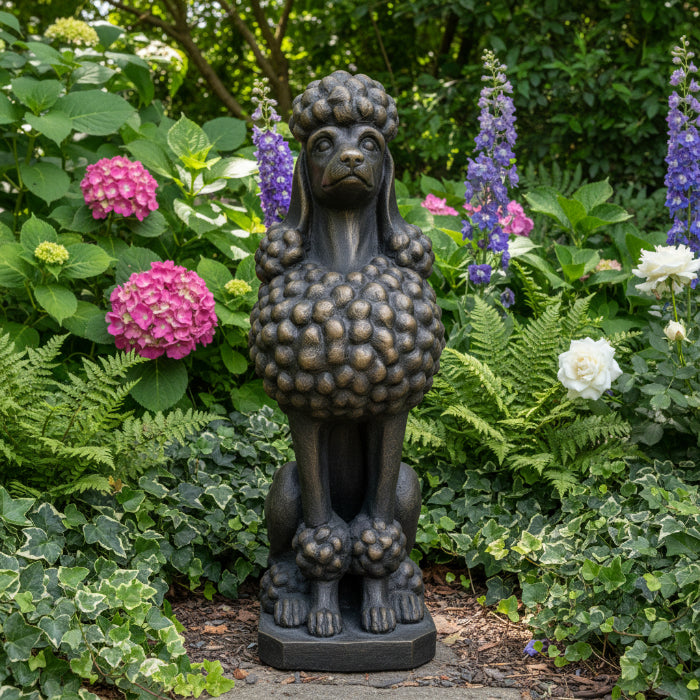 A dark bronze-finished statue of a poodle sitting upright on a rectangular base, photographed against a plain white background.