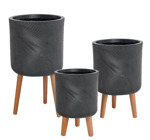 Set of three black textured planters with wooden legs on a white background