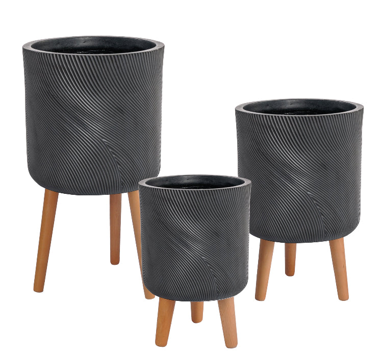 Set of three black textured planters with wooden legs on a white background