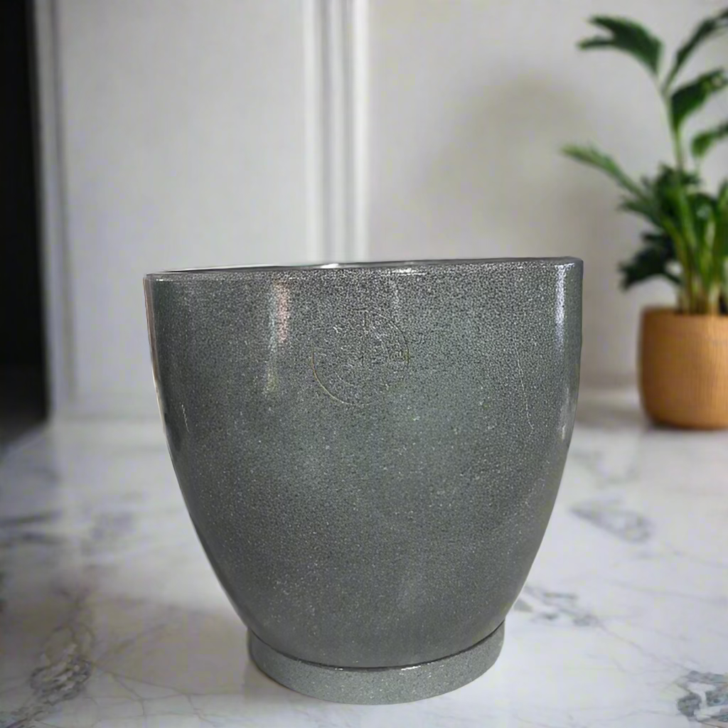 Green pot on a counter with decorative items in the background