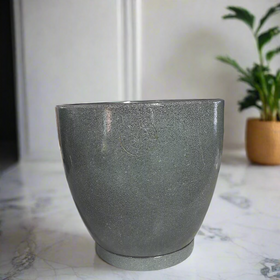 Green pot on a counter with decorative items in the background