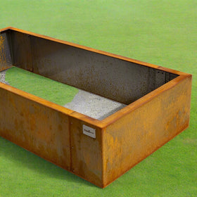 Rust-colored metal planter box on a concrete surface