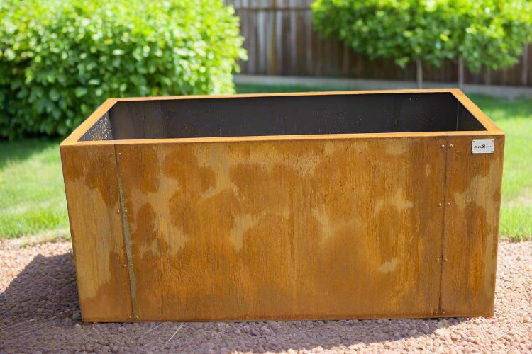 Rust-colored metal planter box on a concrete surface