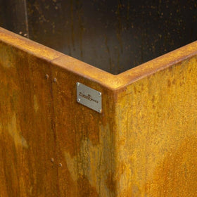 Rust-colored metal surface with a brand label on a dark background