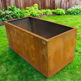 Rust-colored metal planter box on a concrete surface