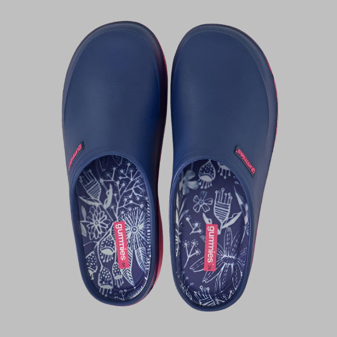 Pair of navy blue clogs with floral patterns on a white background