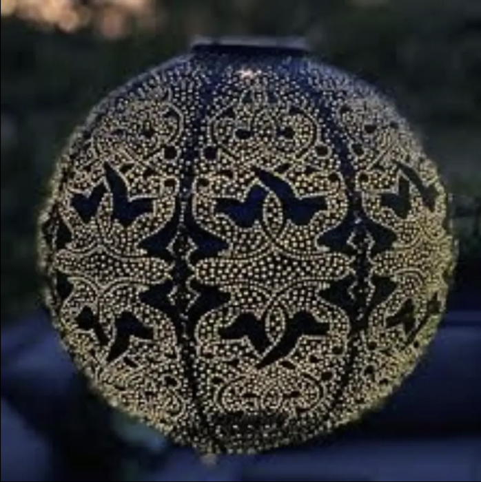Decorative spherical object with intricate black pattern on a blurred background
