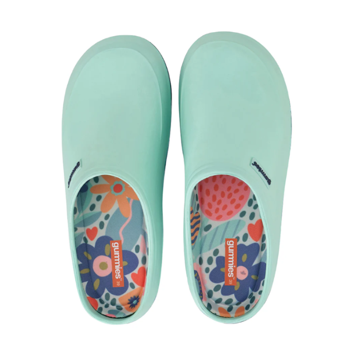 Pair of light blue slip-on shoes with colorful floral patterns on a white background