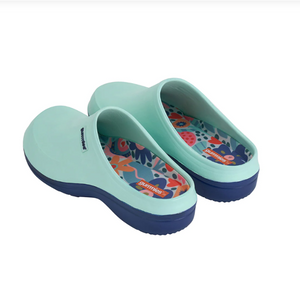 Pair of light blue clogs with floral patterned insoles on a white background