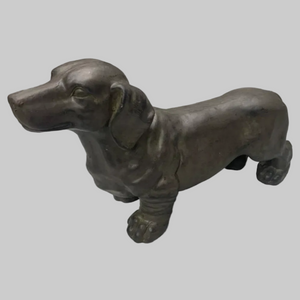 Bronze statue of a dachshund on a white background