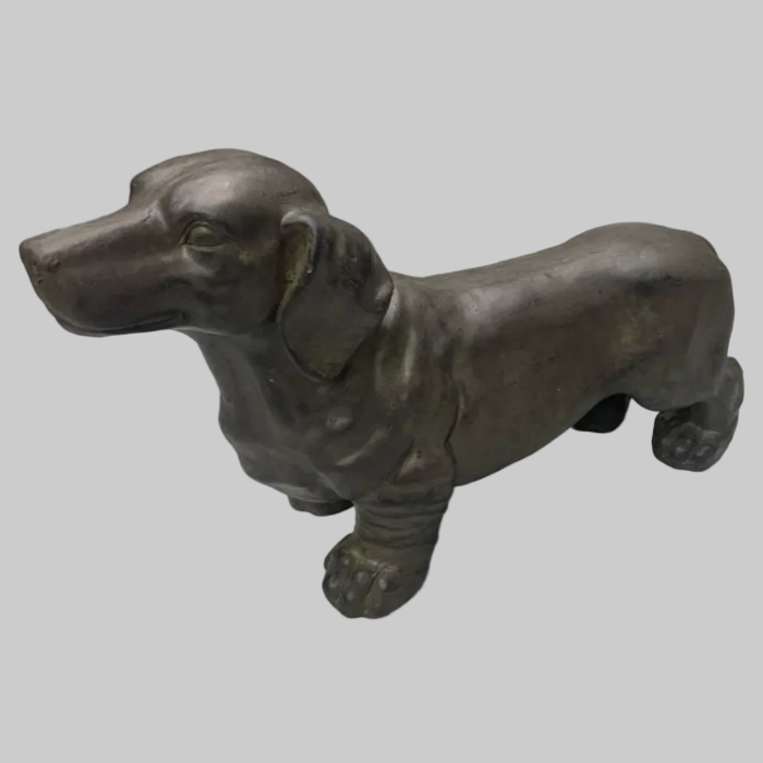 Bronze statue of a dachshund on a white background