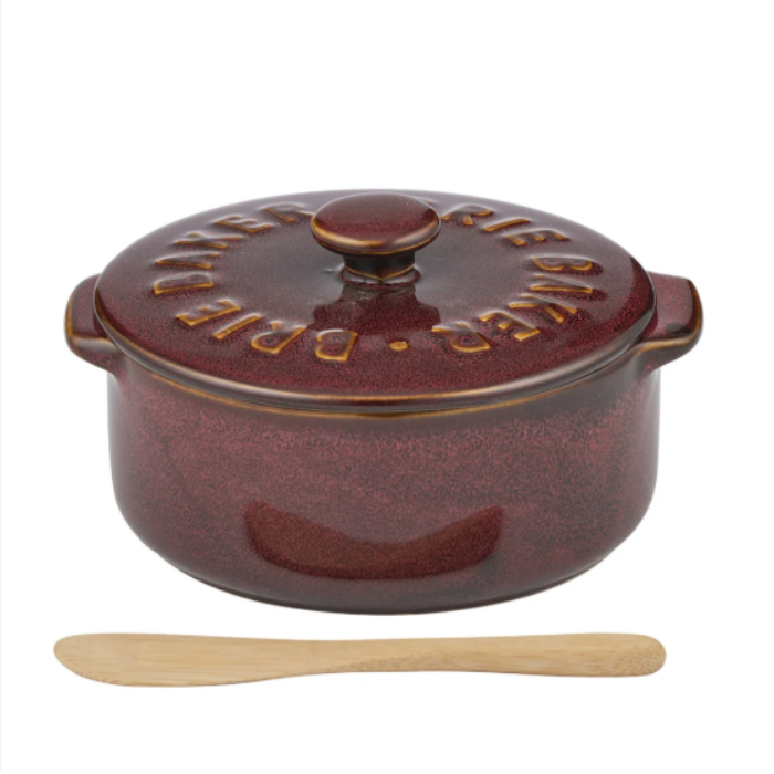 A dark red speckled cast-iron Dutch oven with a matching lid, shown on a white background with a small wooden spatula below it. The lid features embossed text reading 'BRIDGERS'.