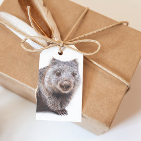 Gift box wrapped in brown paper with a tag featuring an animal illustration on a light background
