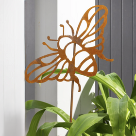 Rust-colored bee-shaped garden stake on a plant with a neutral background