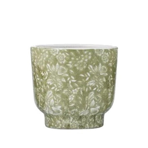 Green ceramic pot with floral pattern on a white background