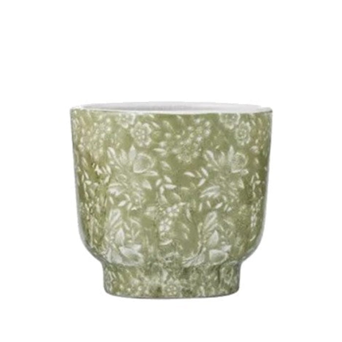 Green ceramic pot with floral pattern on a white background