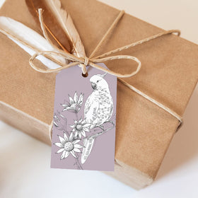 Gift box wrapped in brown paper with a decorative tag featuring a parrot illustration.
