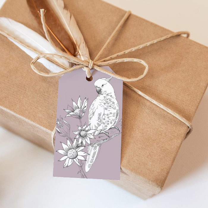 Gift box wrapped in brown paper with a decorative tag featuring a parrot illustration.