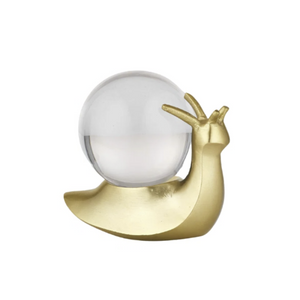 A decorative snail figurine with a polished gold body and a clear glass shell on a plain white background.