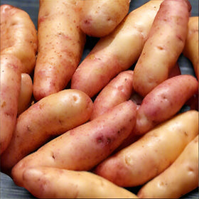 Basket of potatoes on a wooden surface
