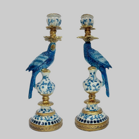 Pair of decorative candle holders with blue parrot designs on a white background