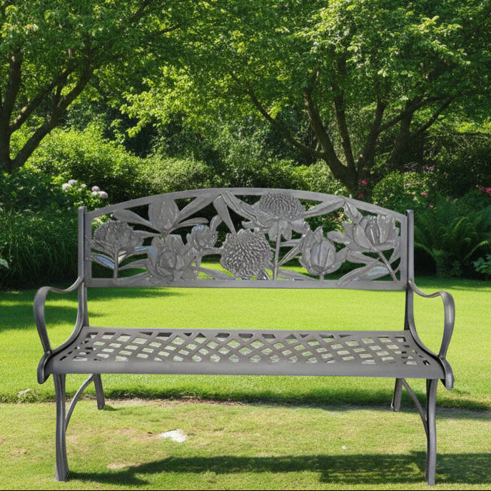 A solid cast iron garden bench with a dark brown and bronze powder-coat finish, featuring hand painted gold highlights and floral patterns.