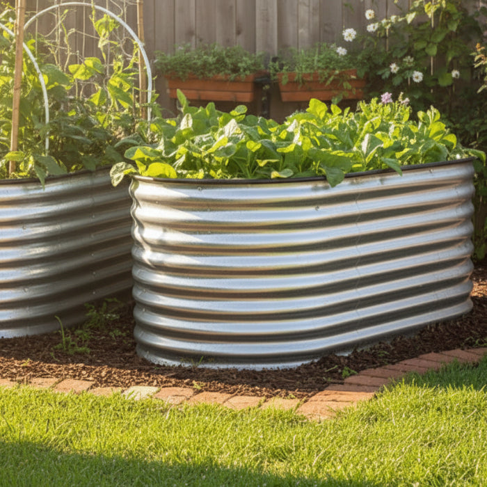 A metal raised garden bed with a zinc finish, situated in an outdoor setting with plants growing inside it.