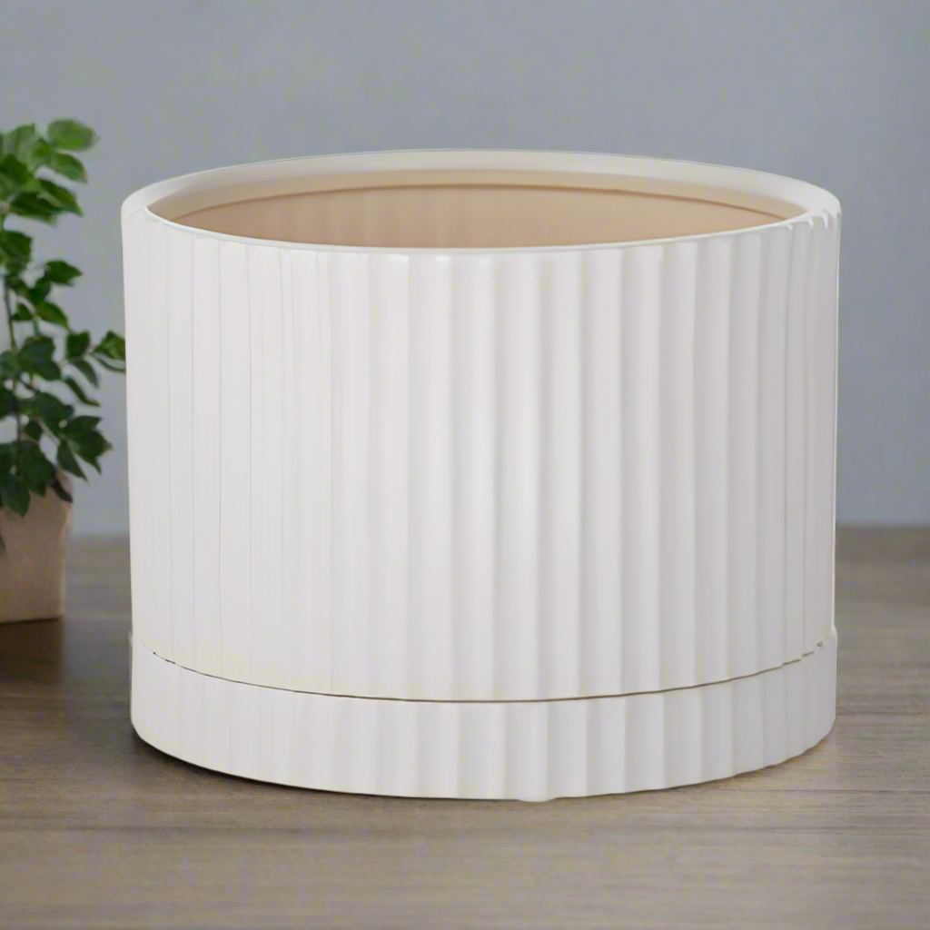 A white ceramic pot with a matching saucer, designed for planting.